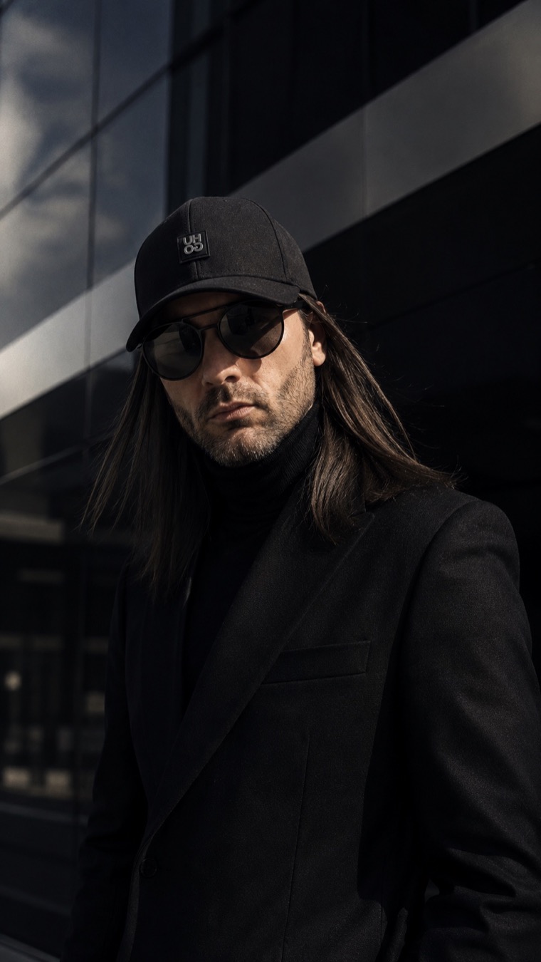 Katze in black coat and sunglasses for the artist press portrait